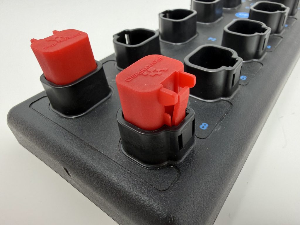 Red Socket Lock sealing plugs installed on a DT-style I/O module