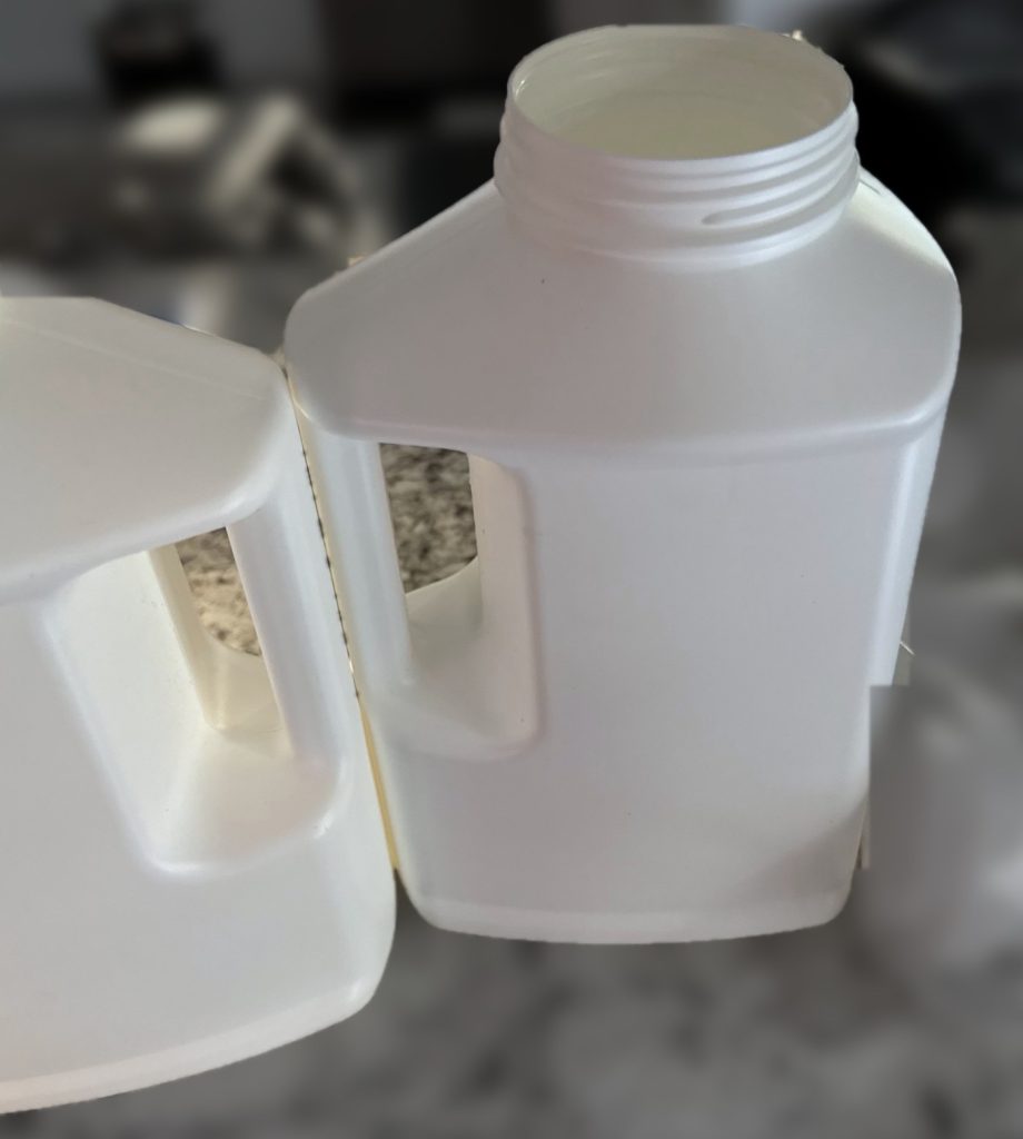 Blow molded bottles with molded handles