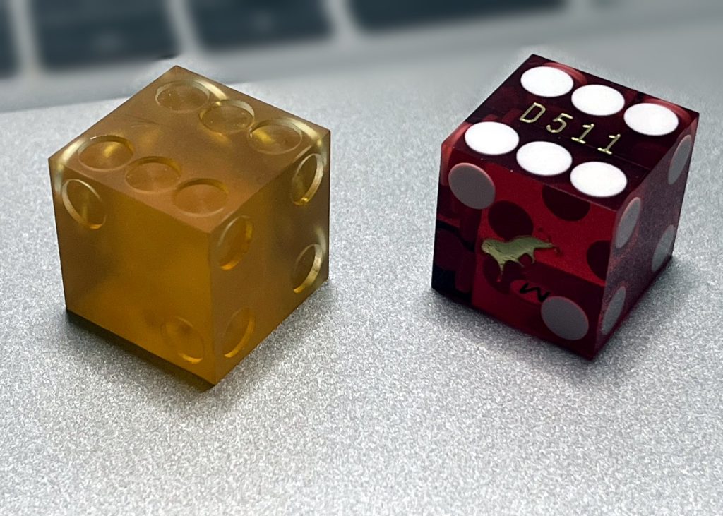 Amber first-shot die next to a finished red molded die